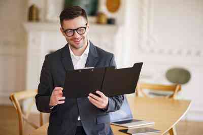 © muse studio - Adobe Stock.com Mann hält Dokumentenmappe