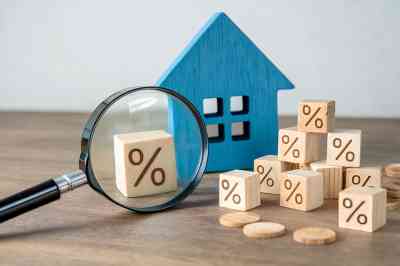 © Foto Fusion - stock.adobe.com Lupe, Holzhaus und Würfel mit Prozentzeichen