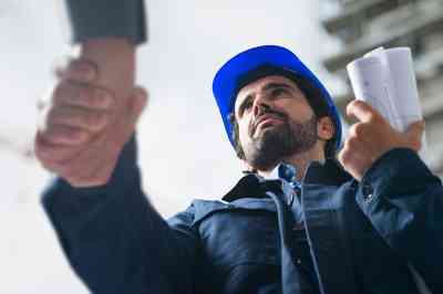 © Minerva Studio - stock.adobe.com Handschlag mit Bauarbeiter